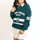 Woman wearing a green and white golf-themed sweater on a white background